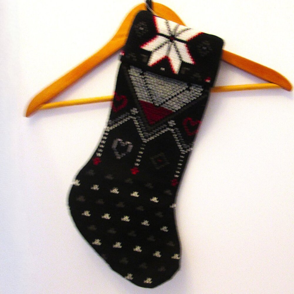 Christmas stuffing stocking of Poinsettas and hearts to hand on the hearth